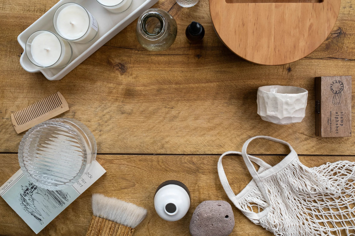 Natural wood chopping board styled with soy wax candles and a net bag on a wooden table.