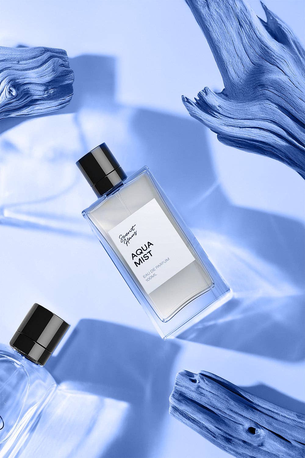 Perfume bottle labelled 'Aqua Mist' on a blue fabric background