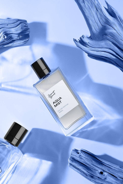 Perfume bottle labelled 'Aqua Mist' on a blue fabric background