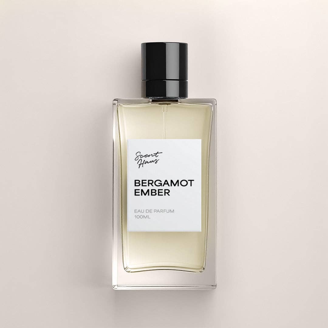 A 100ml bottle of Bergamot Ember Eau de Parfum by Scents of Mars, featuring a clear glass bottle with pale amber liquid, a white label, and a black cap, centered on a warm beige background.