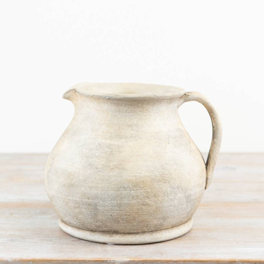 Cici Terracotta Jug Vase with handle displayed on a wooden surface against a neutral background.