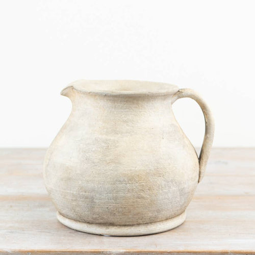 Cici Terracotta Jug Vase with handle displayed on a wooden surface against a neutral background.