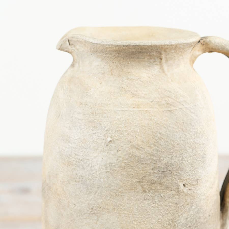 Close-up of the Cici terracotta jug vase showing its textured surface against a light background.