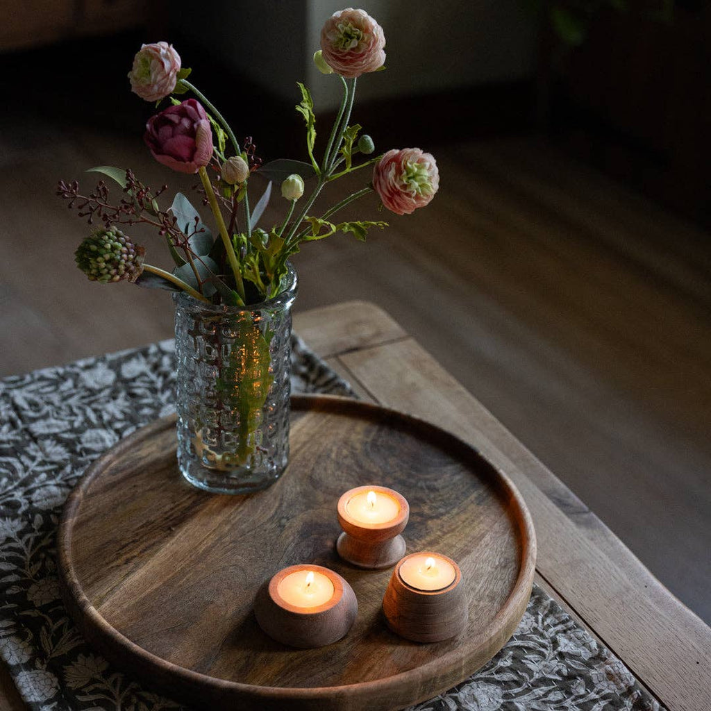 Vase with flowers and three candles on a Cluny round wooden tray.