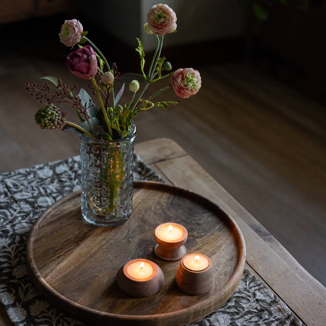 Vase with flowers and three candles on a Cluny round wooden tray.
