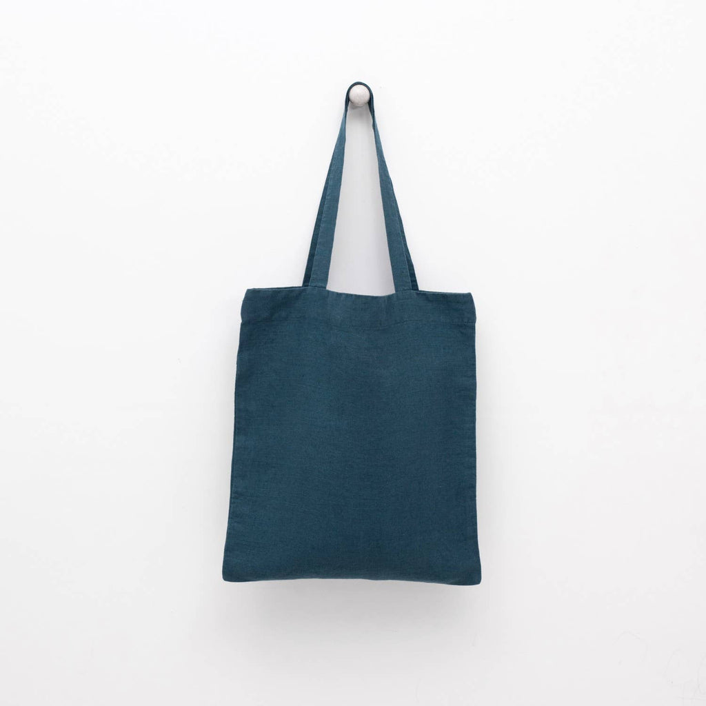 A deep water blue linen tote bag with matching shoulder straps displayed against a plain white background.