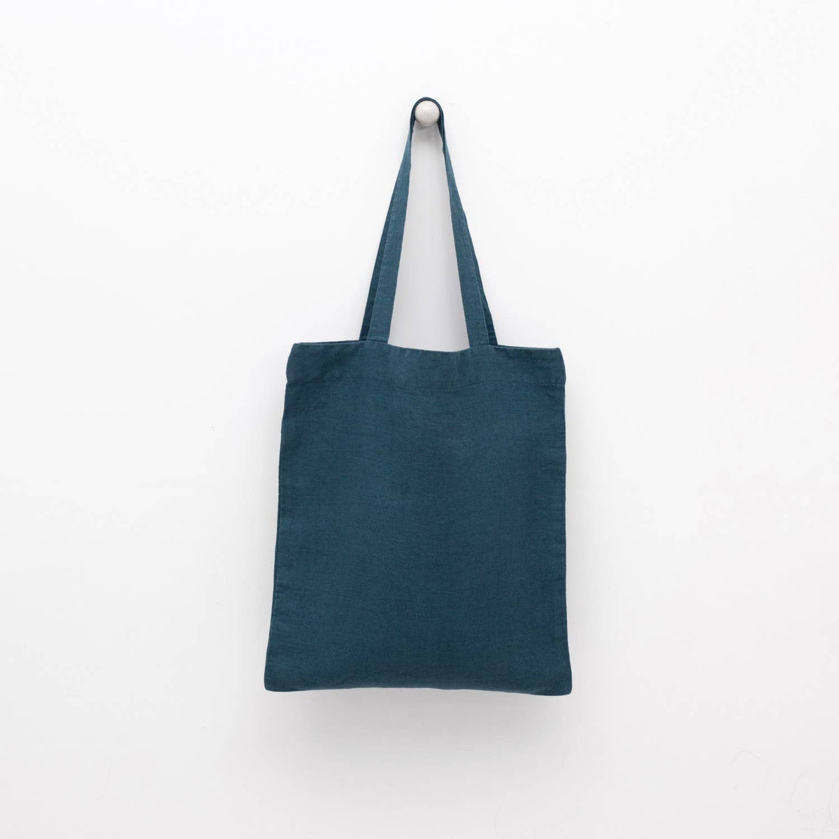 A deep water blue linen tote bag with matching shoulder straps displayed against a plain white background.