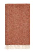 Textured brick coloured British wool blanket with white fringe on a white background