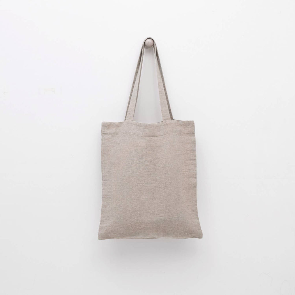A natural linen tote bag with matching shoulder straps displayed against a plain white background.