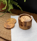 Set of 6 handcrafted olive wood coasters with a matching holder on a white linen cloth.
