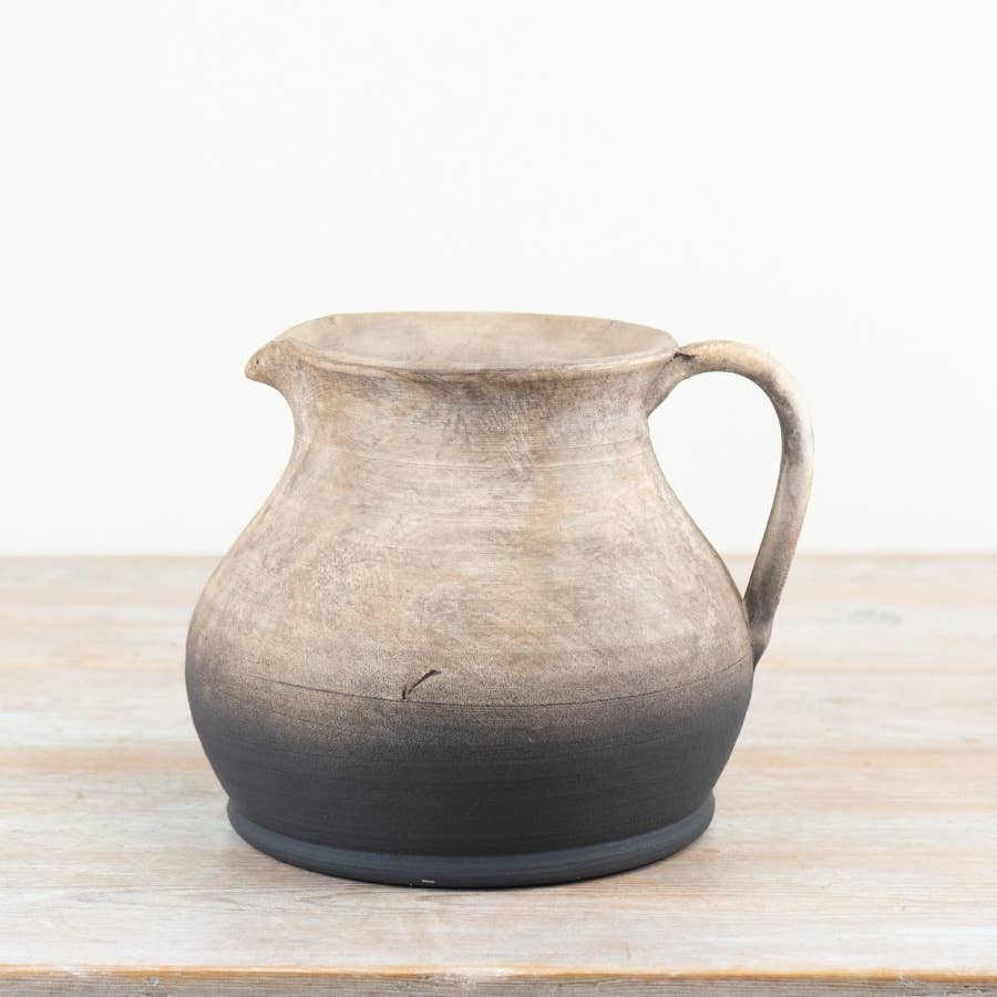 Oti 21.5cm terracotta jug vase with a Roman-inspired handle, displayed on a wooden surface against a plain white background.