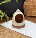 Porto terracotta salt pig with a ribbed cream glazed exterior and raw terracotta interior on a white cloth.