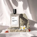 Saffron Luxe perfume bottle on a stone surface with flowers and saffron strands.