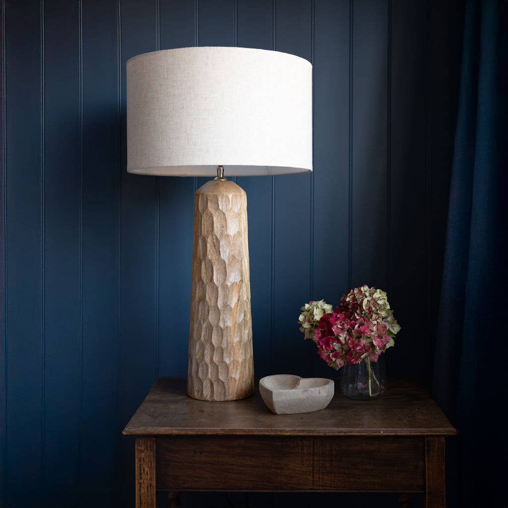Siston wooden table lamp featuring natural material lighting, styled on a wooden tabletop against a dark accent wall.