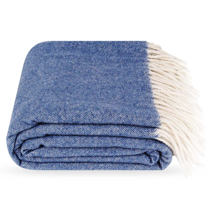 A folded blue cashmere & wool throw blanket with cream fringe, shown on a plain white background.