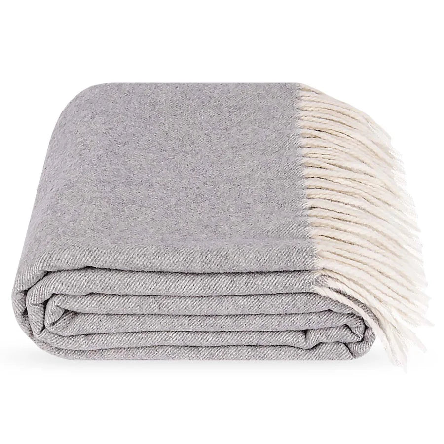 A folded grey polo cashmere and wool throw blanket with cream-colored fringe, shown on a clean white background.