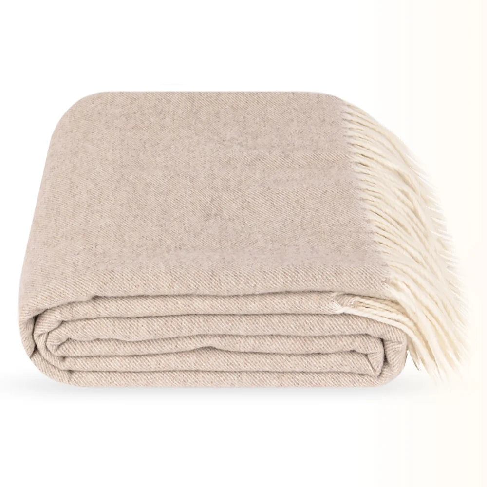 A folded Steppe beige wool throw blanket with cream fringe, photographed on a clean white background.