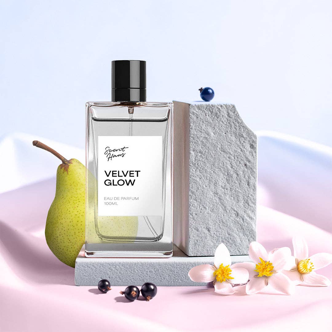 Perfume bottle labeled 'Velvet Glow' with pear, flowers, and berries on a light background